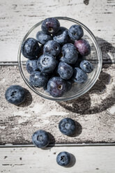 Glass bowl of blueberries on wood, elevated view - SARF000610