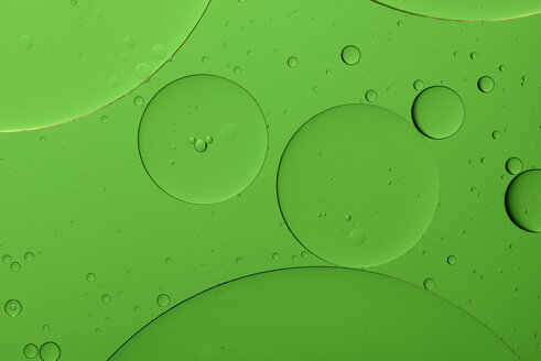 Oil and water in front of green background - MJOF000164