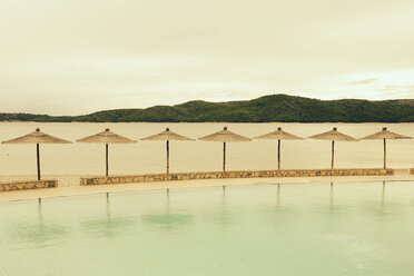 Kroatien, Sibenik, Sonnenschirme, Schwimmbad einer Hotelanlage, Abendstimmung - MEMF000161