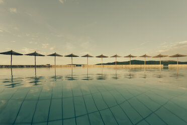 Kroatien, Sibenik, Sonnenschirme, Schwimmbad einer Hotelanlage, Abendstimmung - MEMF000165