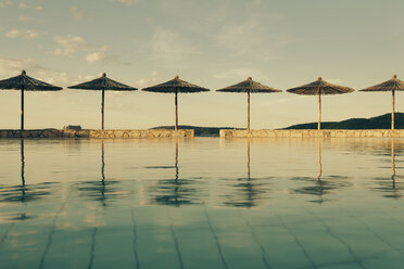 Kroatien, Sibenik, Sonnenschirme, Schwimmbad einer Hotelanlage, Abendstimmung - MEMF000166