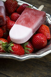 Metallschüssel mit Erdbeer-Eislutscher und Erdbeeren auf Holz - LVF001294