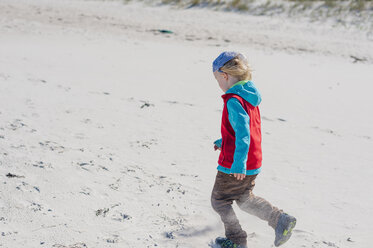 Germany, Mecklenburg-Western Pomerania, Ruegen, Schaabe, Boy walking on windy beach - MJF001224