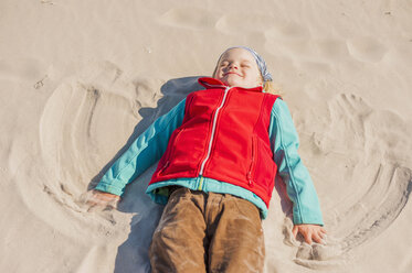Germany, Mecklenburg-Western Pomerania, Ruegen, Schaabe, Boy lying in sand on beach - MJF001226