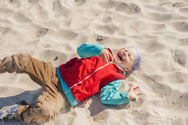 Germany, Mecklenburg-Western Pomerania, Ruegen, Schaabe, Boy lying in sand on beach - MJF001227