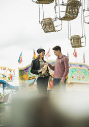 Portrait of teenage couple with popcorn at fun fair - UUF000634