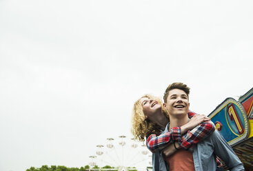 Portrait of happy teenage couple at fun fair - UUF000642