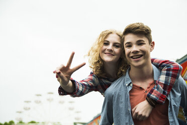 Porträt eines glücklichen Teenager-Paares mit Victory-Zeichen - UUF000639