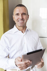 Portrait of smiling senior doctor with tablet computer - MFF001124