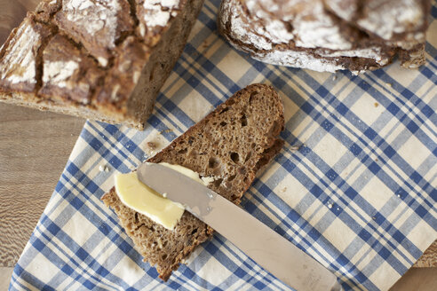 Einbuttern einer Scheibe Vollkornbrot, Ansicht von oben - SABF000007