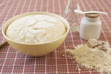 Bowl of raw yeast dough and ingredients of yeast dough on cloth - SABF000014