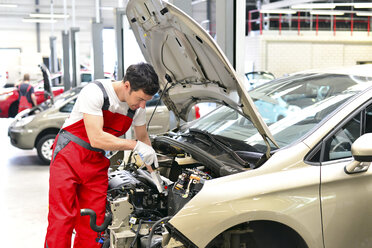 Automechaniker in einer Werkstatt bei der Arbeit am Auto - LYF000002