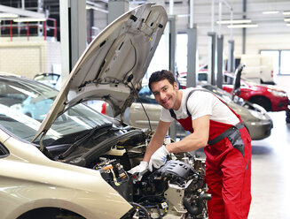 Automechaniker in einer Werkstatt bei der Arbeit am Auto - LYF000013