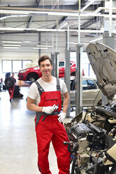 Lächelnder Automechaniker in einer Werkstatt - LYF000014