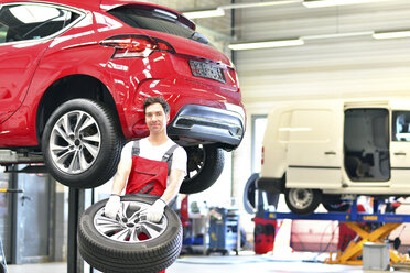 Car mechanic in a workshop changing tire - LYF000016