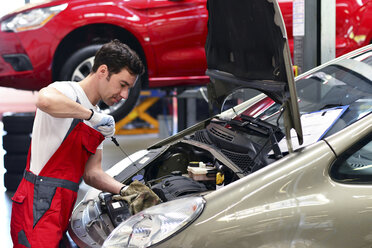 Automechaniker in einer Werkstatt bei der Arbeit am Auto - LYF000019