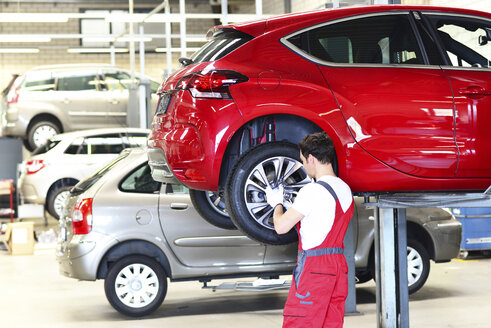 Automechaniker in einer Werkstatt beim Reifenwechsel - LYF000021