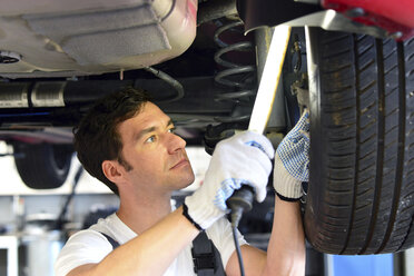 Automechaniker in einer Werkstatt bei der Arbeit am Auto - LYF000022