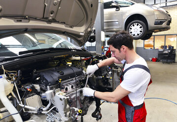 Automechaniker in einer Werkstatt bei der Arbeit am Auto - LYF000025