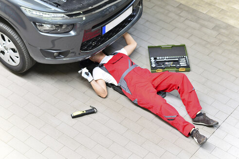 Car mechanic in a workshop working at car - LYF000004