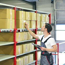 Worker in warehouse controlling goods - LYF000037