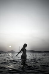 Naked young woman walking in the sea by twilight - AJF000041