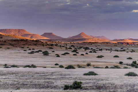 Afrika, Namibia, Damaraland, Blick auf Grasland und Vulkane bei Sonnenuntergang, lizenzfreies Stockfoto