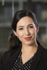 Portrait of smiling business woman in front of glass pane - FKF000486