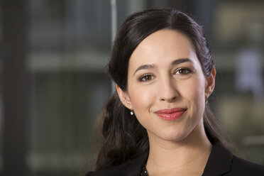 Portrait of smiling business woman in front of glass pane - FKF000487