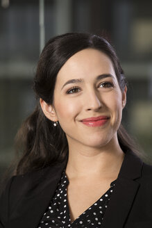 Portrait of smiling business woman in front of glass pane - FKF000488