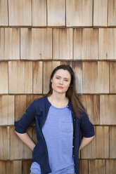 Portrait of creative business woman in front of wood shingle panelling - FKF000506