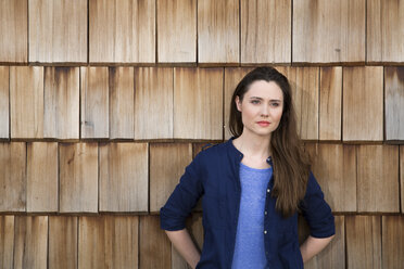Portrait of creative business woman in front of wood shingle panelling - FKF000507