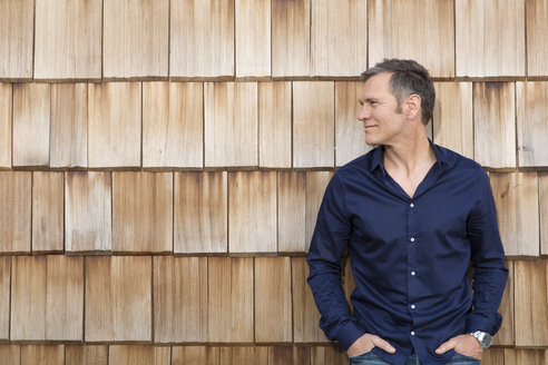 Portrait of creative business man in front of wood shingle panelling - FKF000511