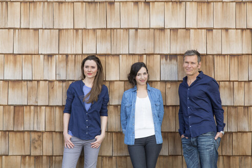 Group picture of three creative business people in front of wood shingle panelling - FKF000517