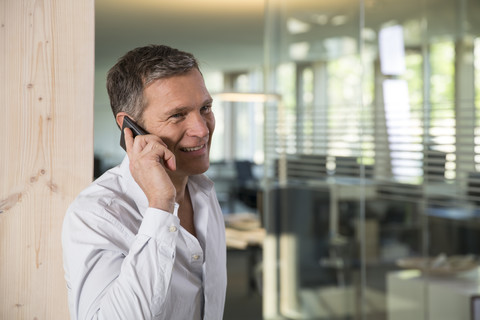 Porträt eines Geschäftsmannes, der mit einem Smartphone telefoniert, lizenzfreies Stockfoto