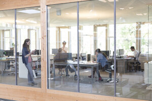 Team von fünf Geschäftsleuten an Arbeitsplätzen in einem modernen Büro - FKF000559