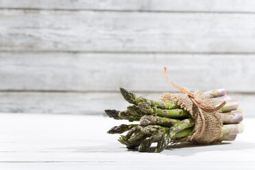 Bunch of green asparagus in front of white wood - MAEF008340