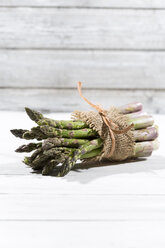 Bunch of green asparagus in front of white wood - MAEF008341