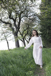 Junge Frau im weißen Kleid auf dem Fußweg - VTF000256
