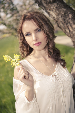 Porträt einer jungen Frau mit gelben Blumen, lizenzfreies Stockfoto