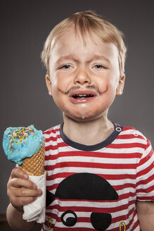 Porträt eines weinenden kleinen Jungen mit angemaltem Bart und Eiscreme - OJF000028