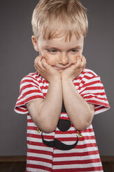 Portrait of little boy holding head in his hands - OJF000039