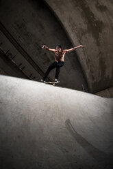 Skateboarder performing trick at skateboard park - KJ000297