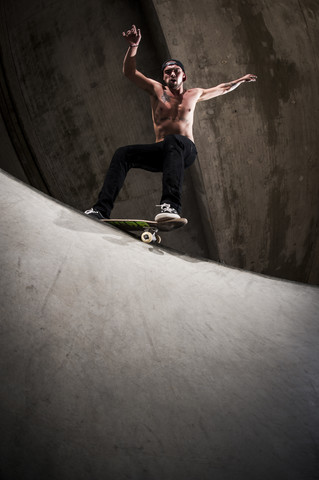 Skateboarder bei einem Trick im Skateboardpark, lizenzfreies Stockfoto