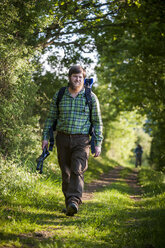 Deutschland, Rheinland-Pfalz, Moselsteig, junger Mann beim Wandern mit Rucksack und Wanderstöcken - PAF000703