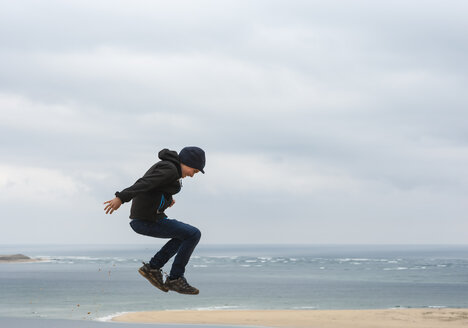 Frankreich, Aquitanien, Gironde, Pyla sur Mer, Dune du Pilat, springender Junge auf Sanddüne - JBF000141