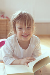 Porträt eines lächelnden kleinen Mädchens mit Buch - LVF001345
