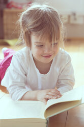 Portrait of smiling little girl with book - LVF001346