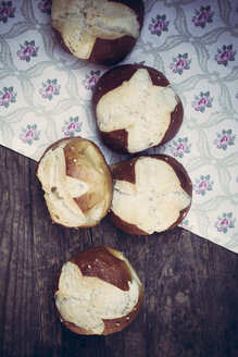 Five pretzel rolls on cloth and wood, elevated view - LVF001350