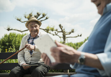 Deutschland, Worms, Zwei alte Männer benutzen Tablet-Computer im Park - UUF000700